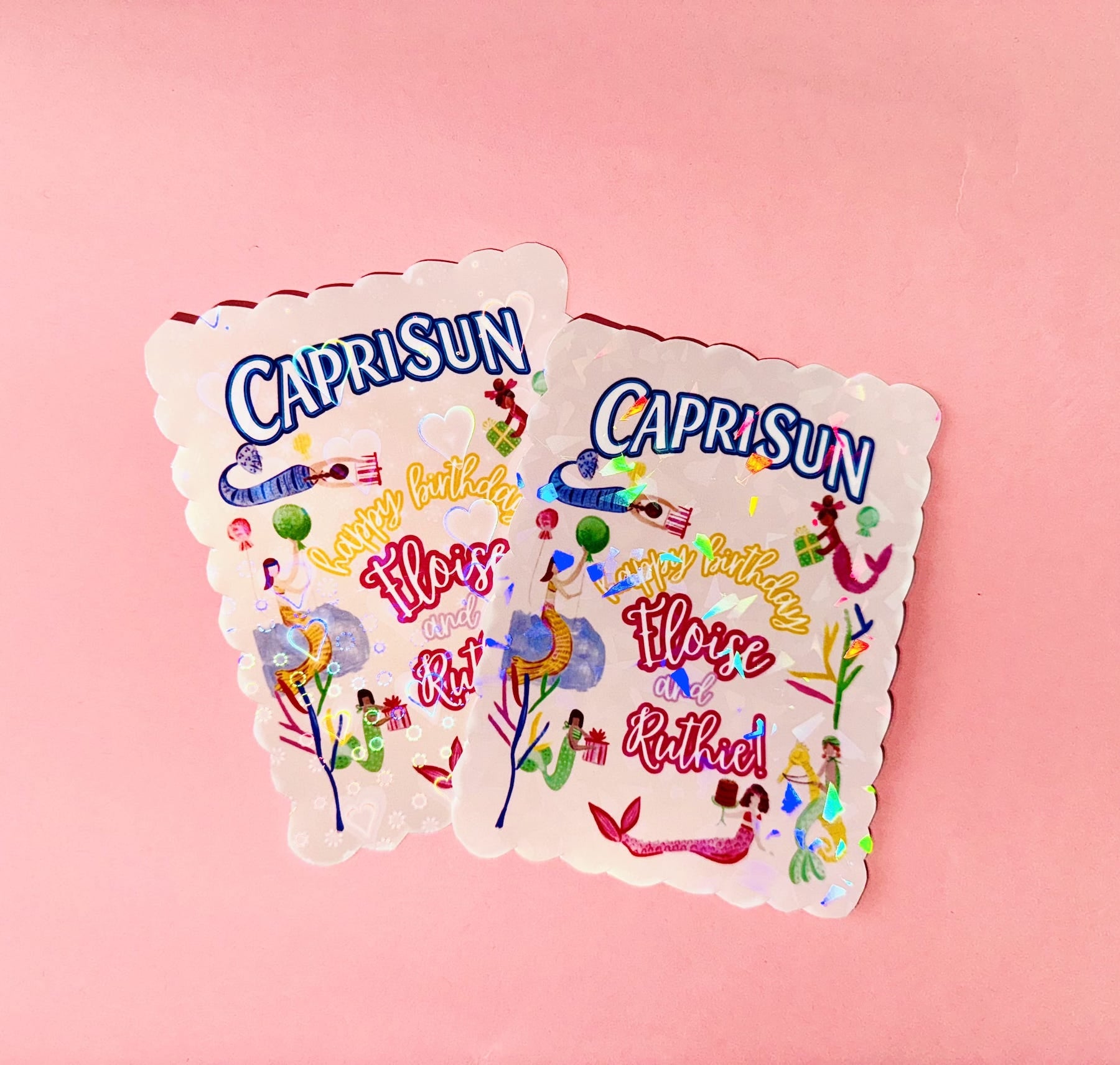 Two Capri Sun juice pack party favors with colorful graphics on a pink background