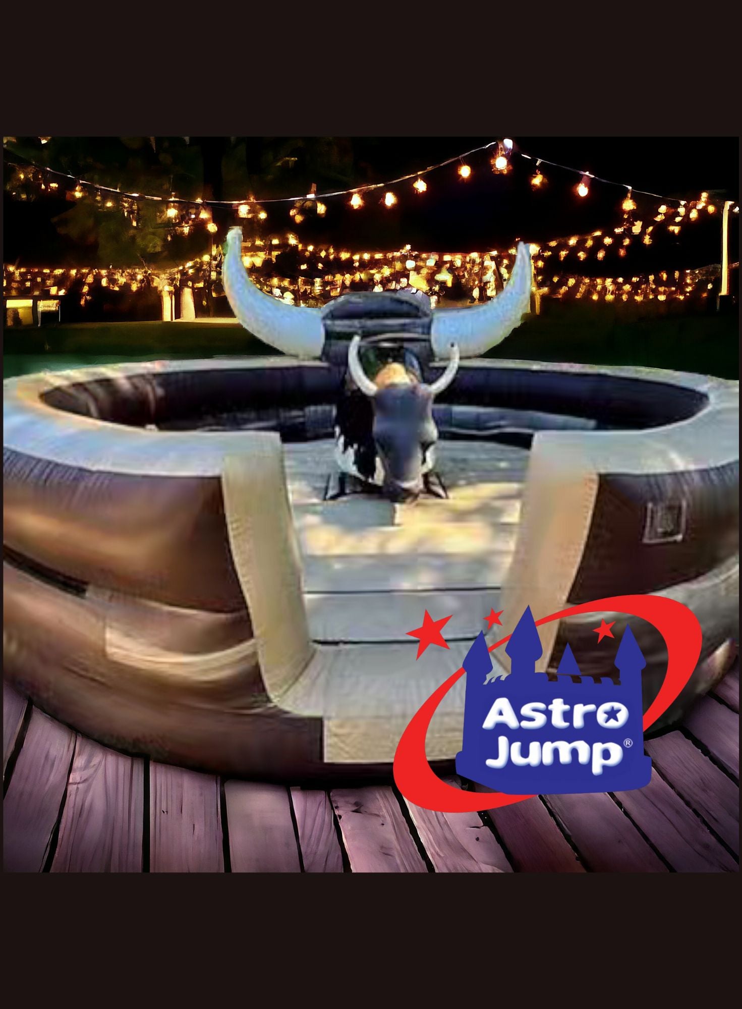Inflatable bull ride with Astro Jump logo at night with string lights