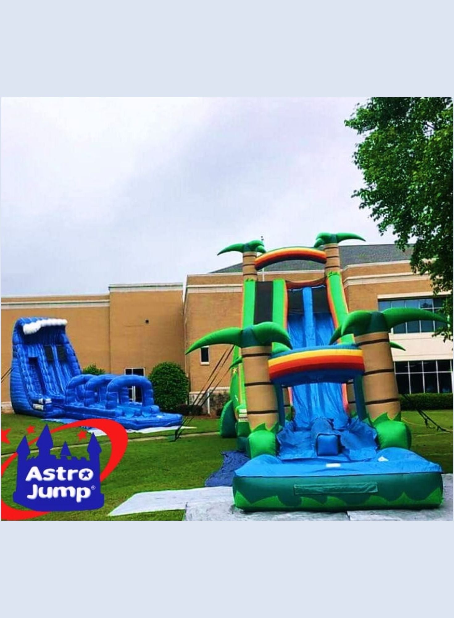 Inflatable water slide with Astro Jump logo in front of a building