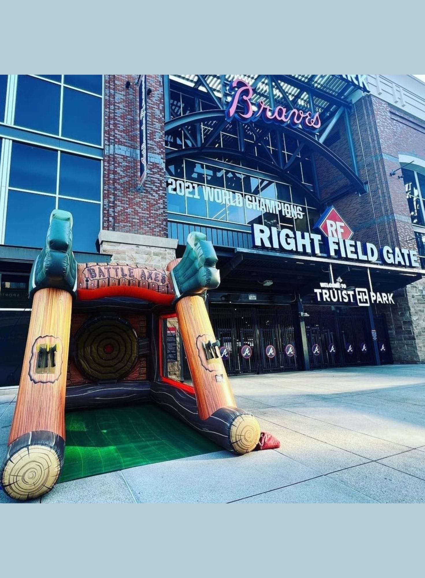 Inflatable bat and ball structure in front of a stadium with 'Braves' branding.