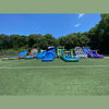 Colorful inflatable water slides on a grassy field with trees in the background
