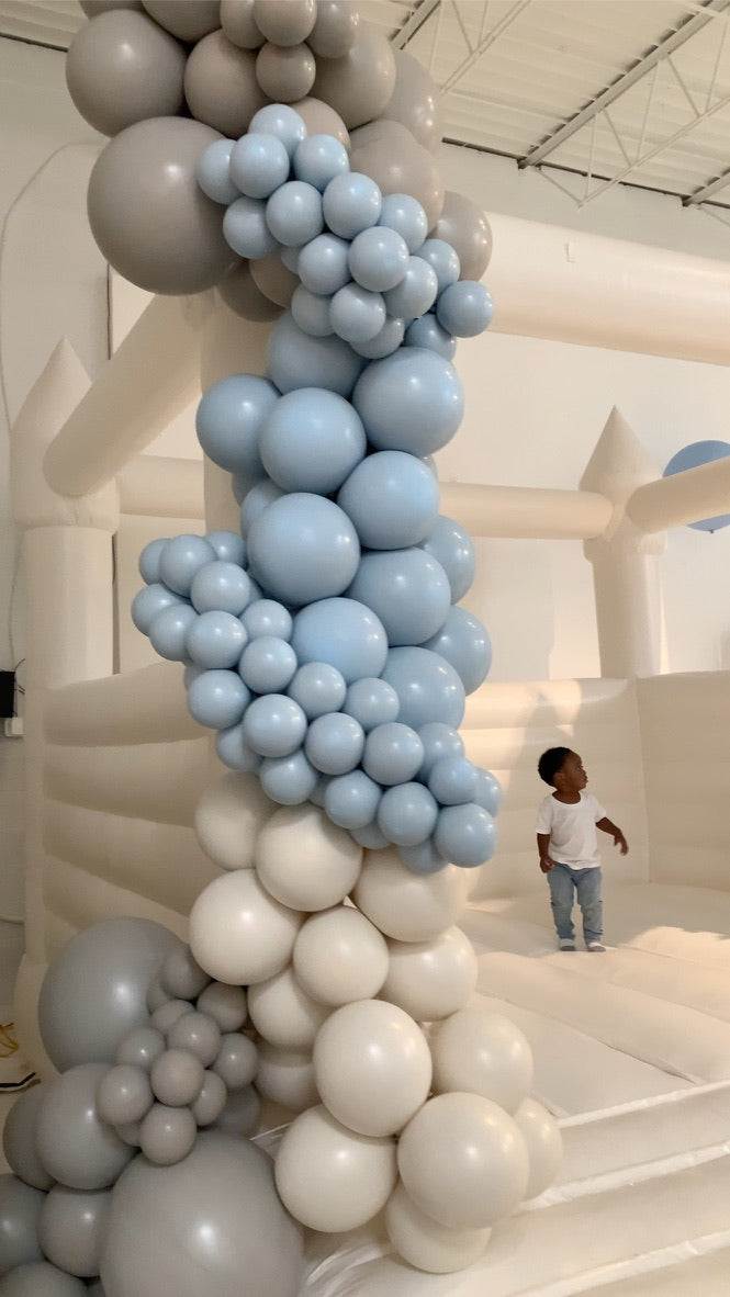 Balloon garland and white bounce house rental at a kids birthday party in Atlanta