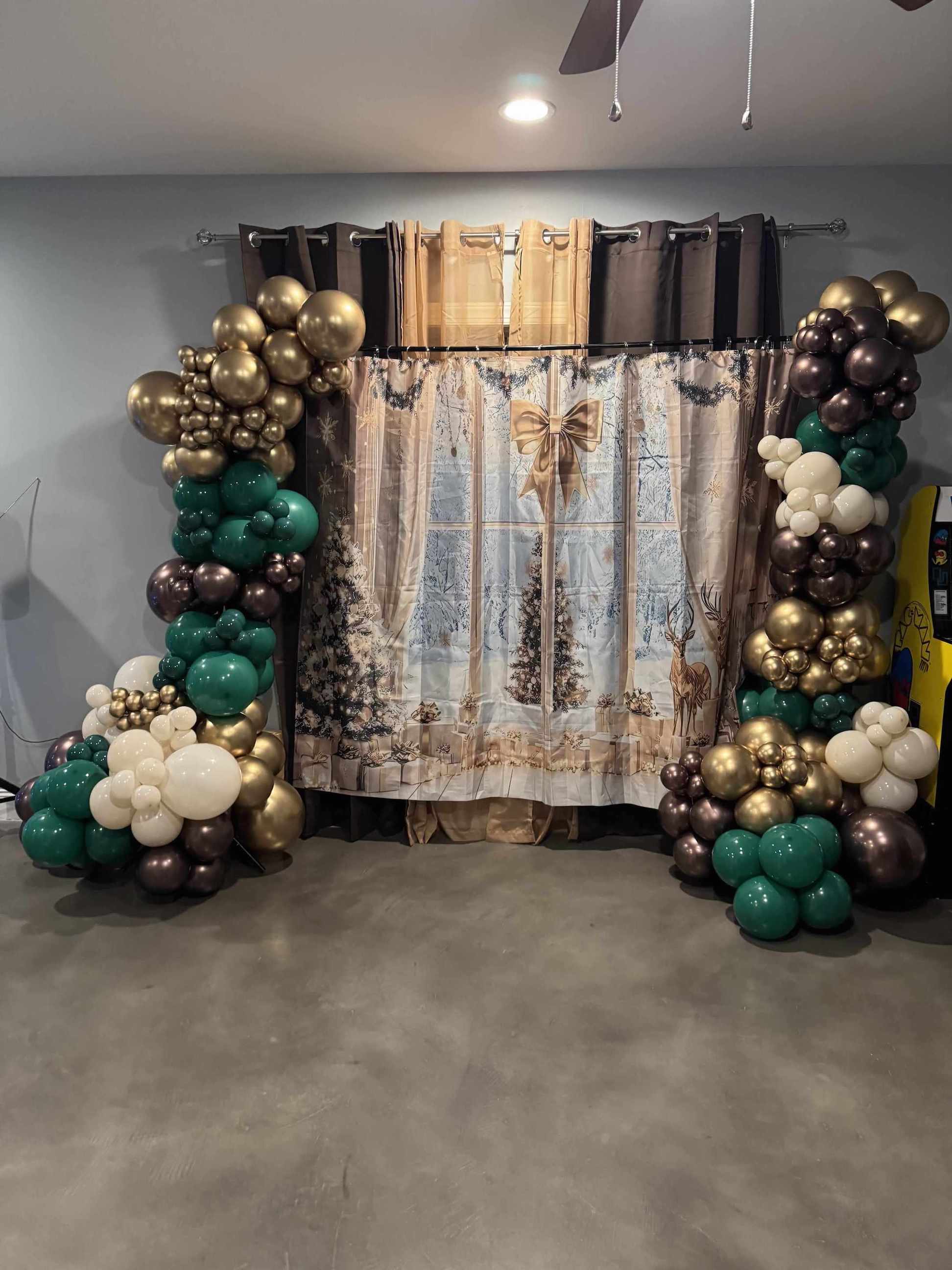 Decorative arch with balloons and a patterned curtain in the background