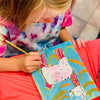 Child painting a colorful picture of a cartoon character on a red blanket at a painting birthday party.