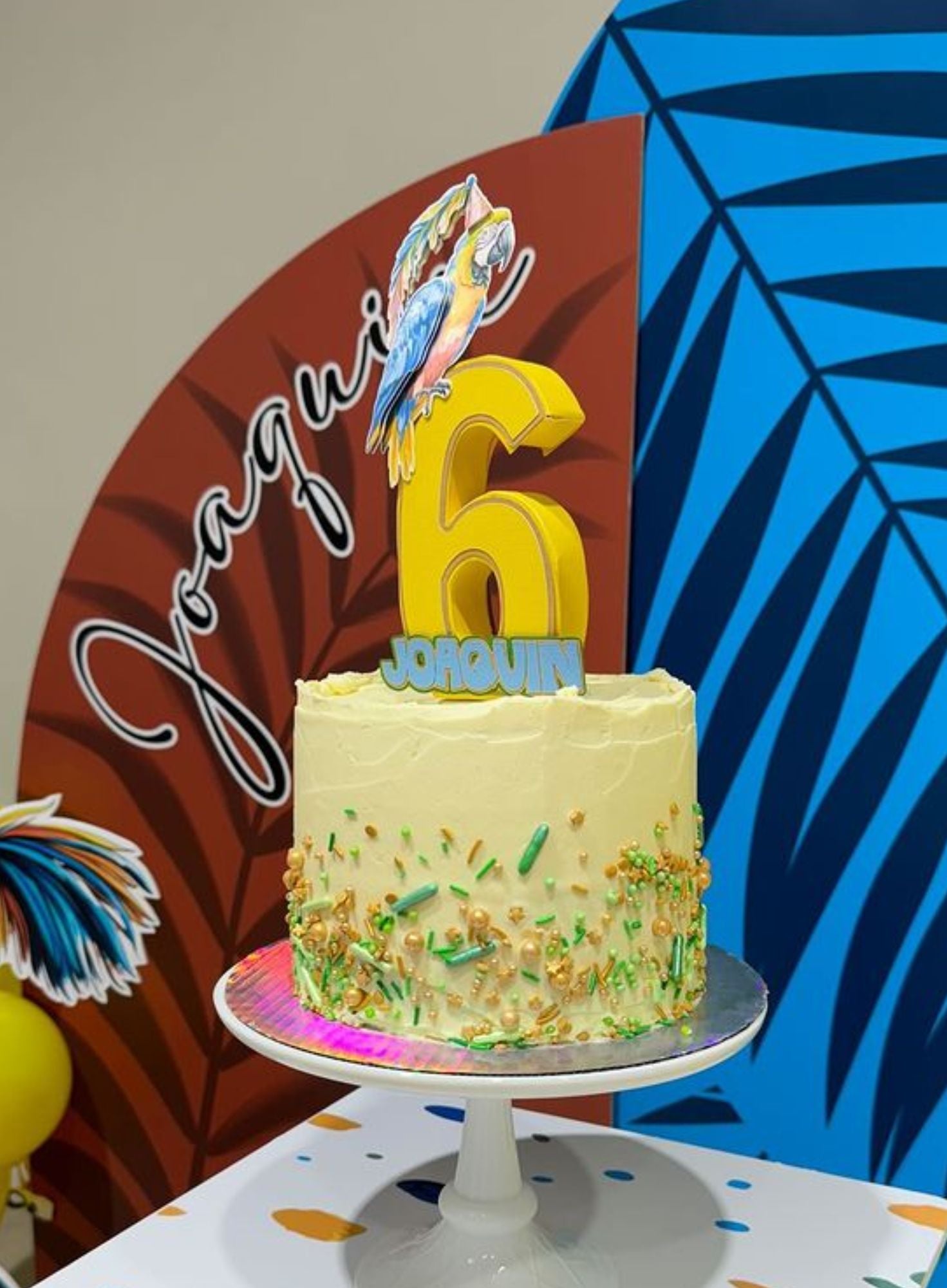 Birthday cake with custom cake topper number '6' topper against a colorful background