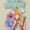 Birthday cake topper with a singer, guitar, and 'Happy Birthday' text on a light gray background.