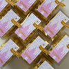 Small party favors for a kids birthday party with pink labels and 'Eleanor' text arranged in a grid.