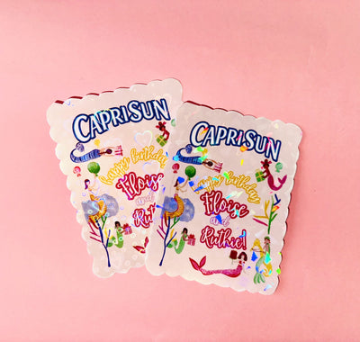 Two Capri Sun juice pack party favors with colorful graphics on a pink background