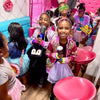 Children in colorful costumes and accessories in a spa party bus in Atlanta.