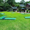 Mobile Miniature golf course set up on a grassy area with buildings and trees in the background. for a teen birthday party | Confetti Jar