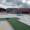 Mobile putt putt golf course with inflatable slides in the background for a party | Confetti Jar