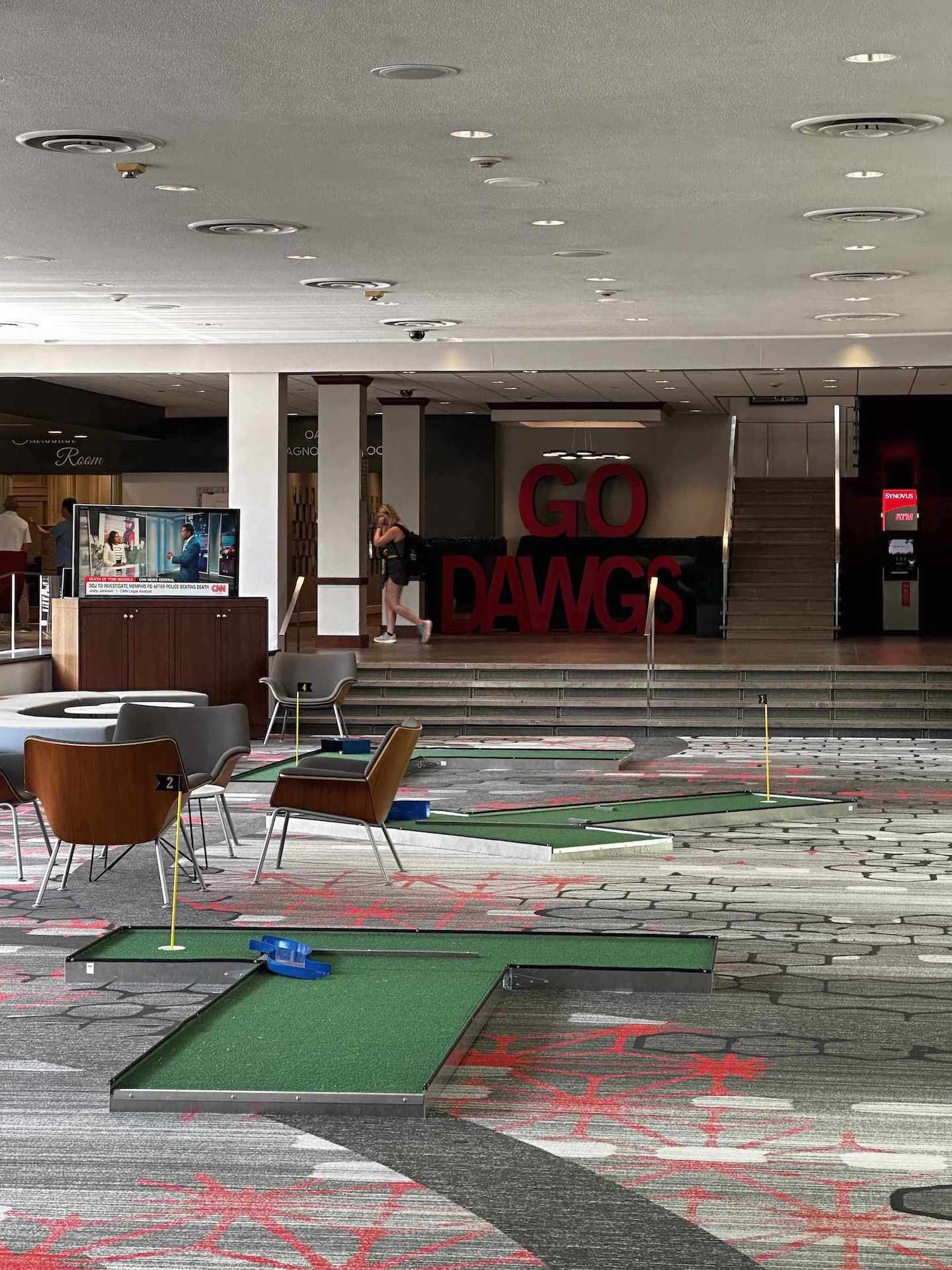 Indoor mini golf course with 'GO DAWGS' sign in a building interior for an event in Atlanta GA | Confetti Jar