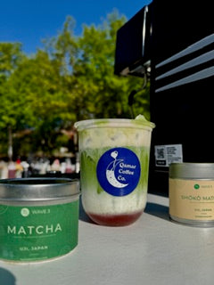 Matcha coffee and ingredients on a table with a blurred outdoor background