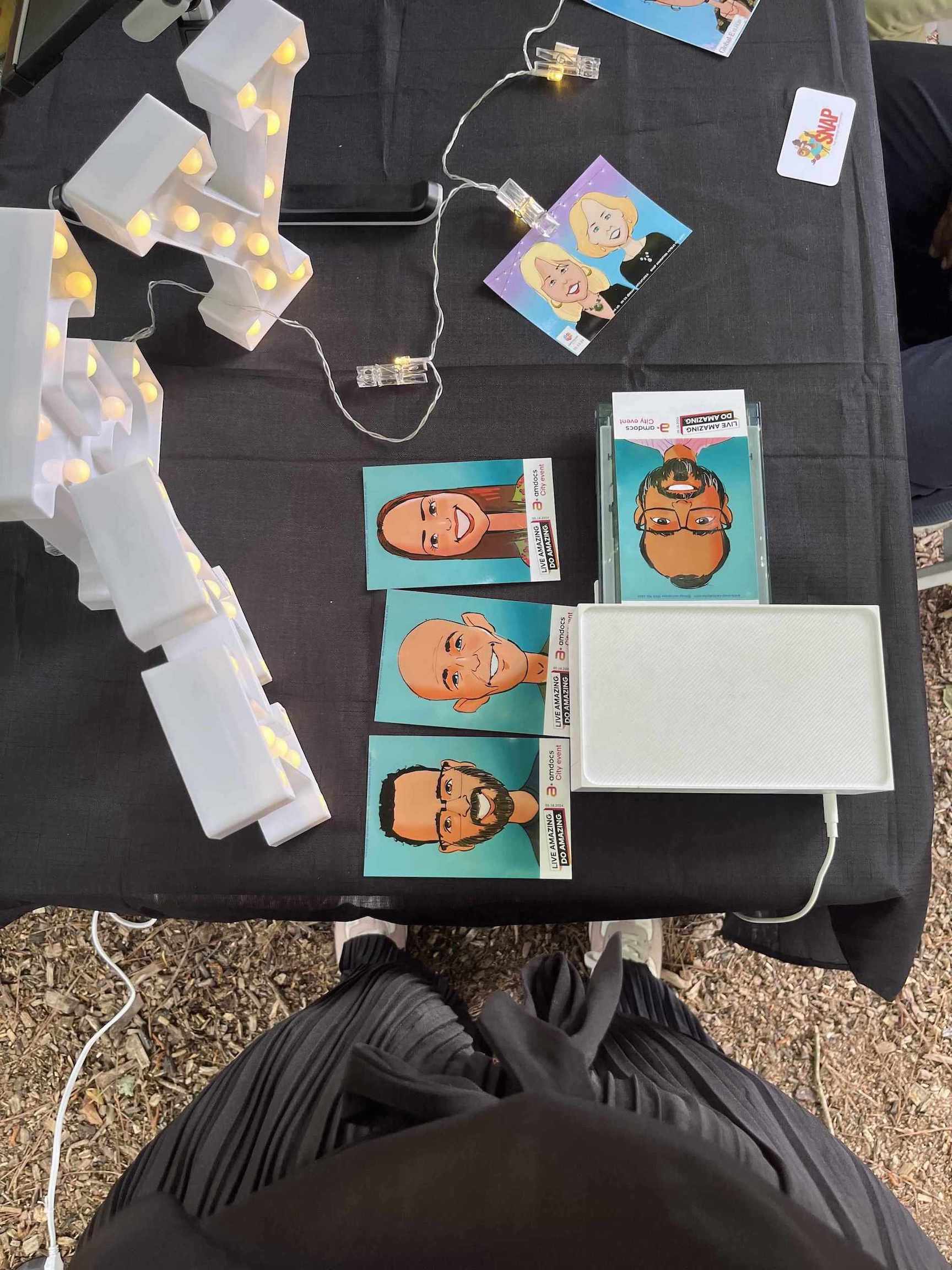 Digital caricatures at Atlanta event on a black surface.