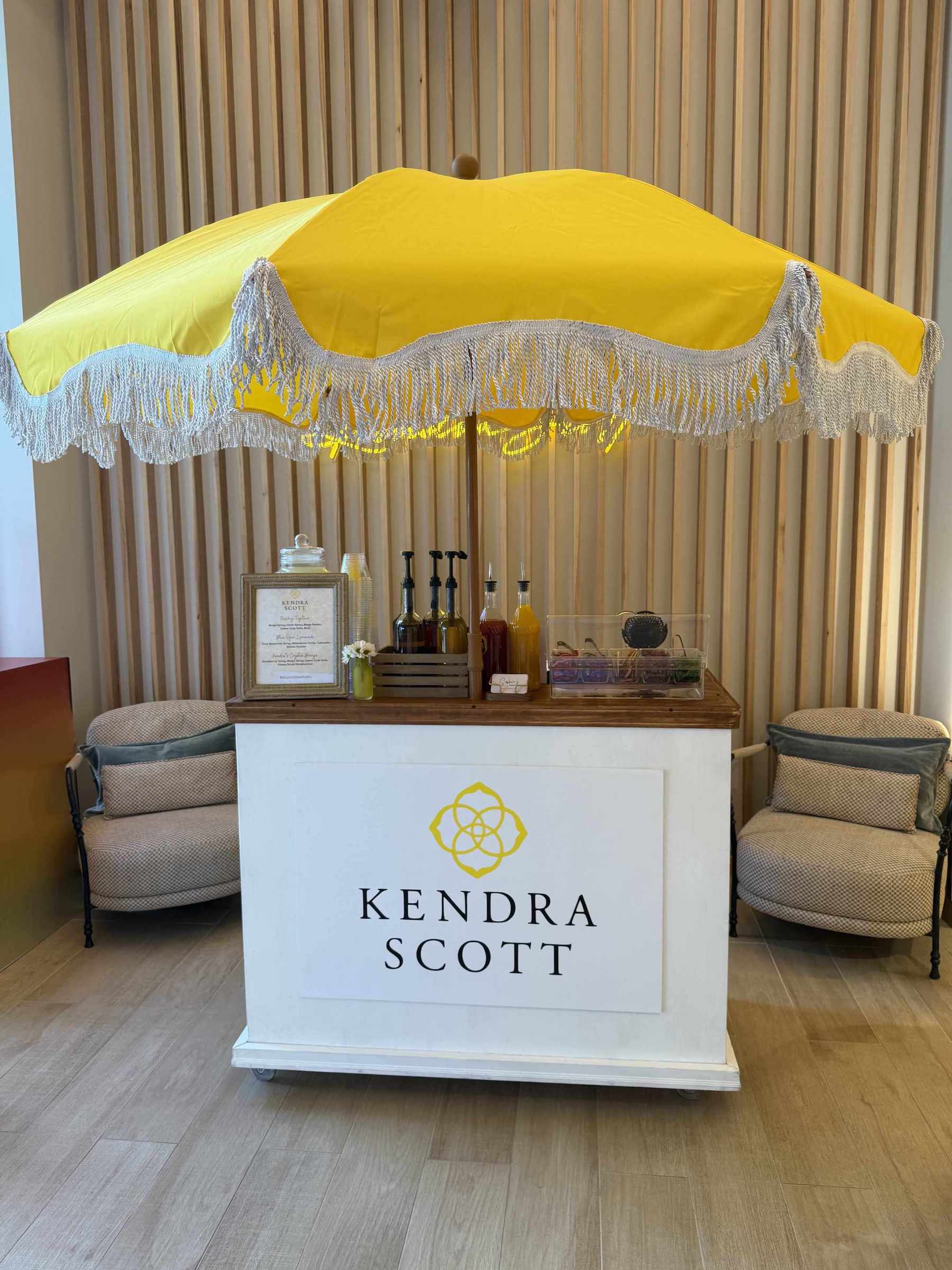 Kendra Scott display with yellow canopy and product display inside a room | Dessert Cart Atlanta | Confetti Jar