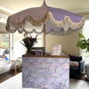 Umbrella with decorative fringe over a branded counter in a room with furniture and decor | Dessert Cart Atlanta | Confetti Jar