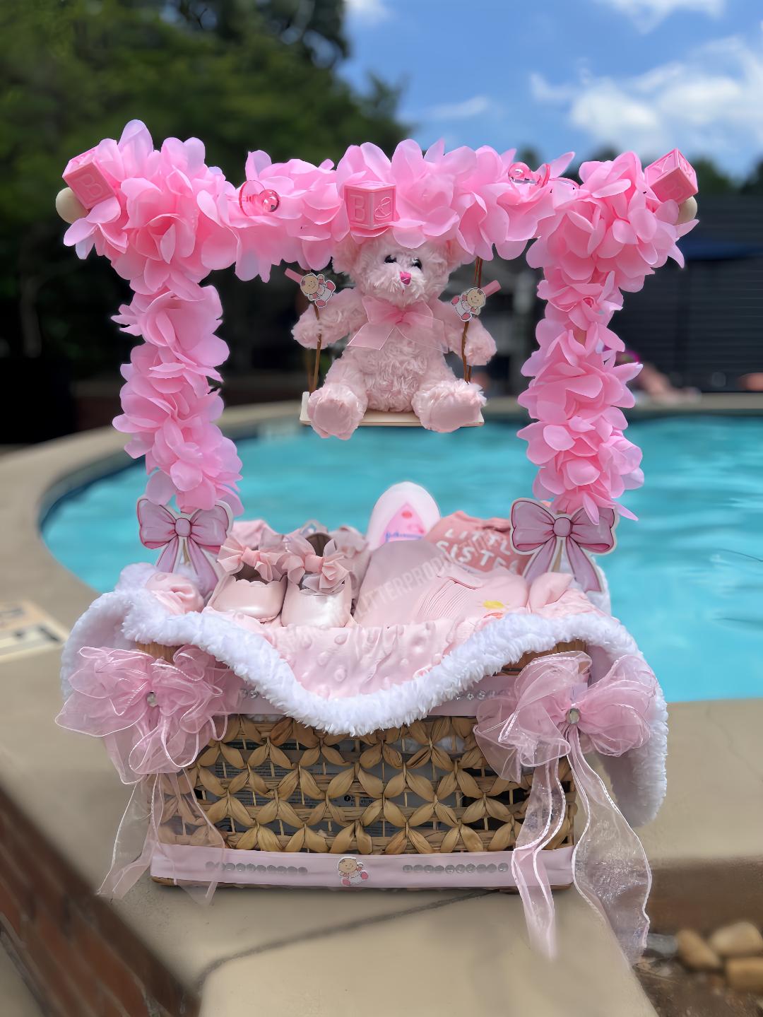 Decorative baby gift basket with pink flowers and teddy bear near a pool