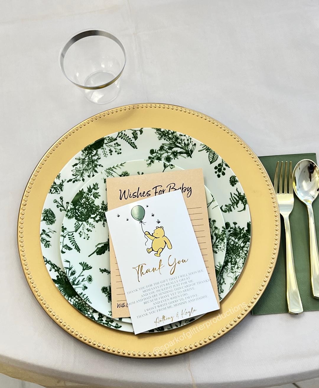 Table setting with a decorative plate, card, and cutlery on a white surface