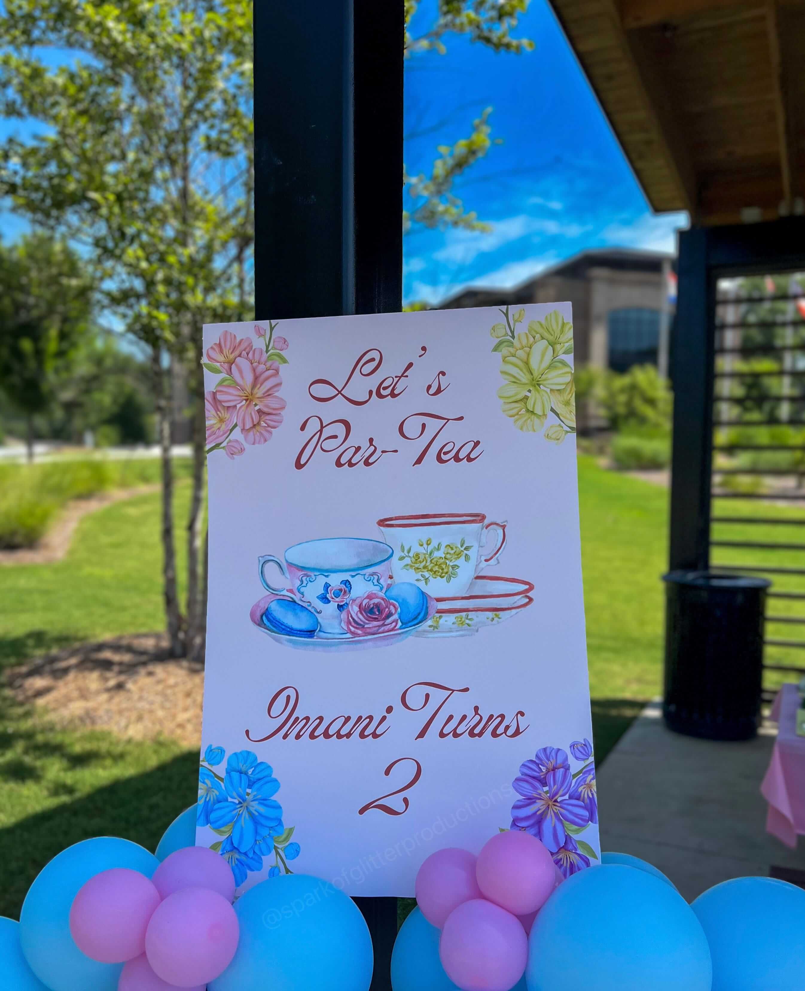 Party invitation card for a tea party themed birthday with balloons in the foreground.