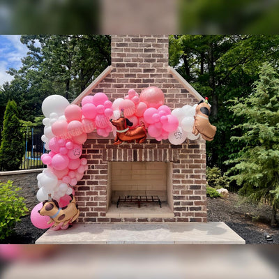 Brick fireplace with balloon arch and cartoon character decorations outdoors