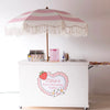 Waffle cart in Atlanta with a pink and white striped umbrella labeled 'Kari's Berry ONE-derful Waffles' on a white background.