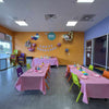 Children's party room with tables set for a birthday celebration, balloons, and decorations at The Little Gym in Johns Creek GA.
