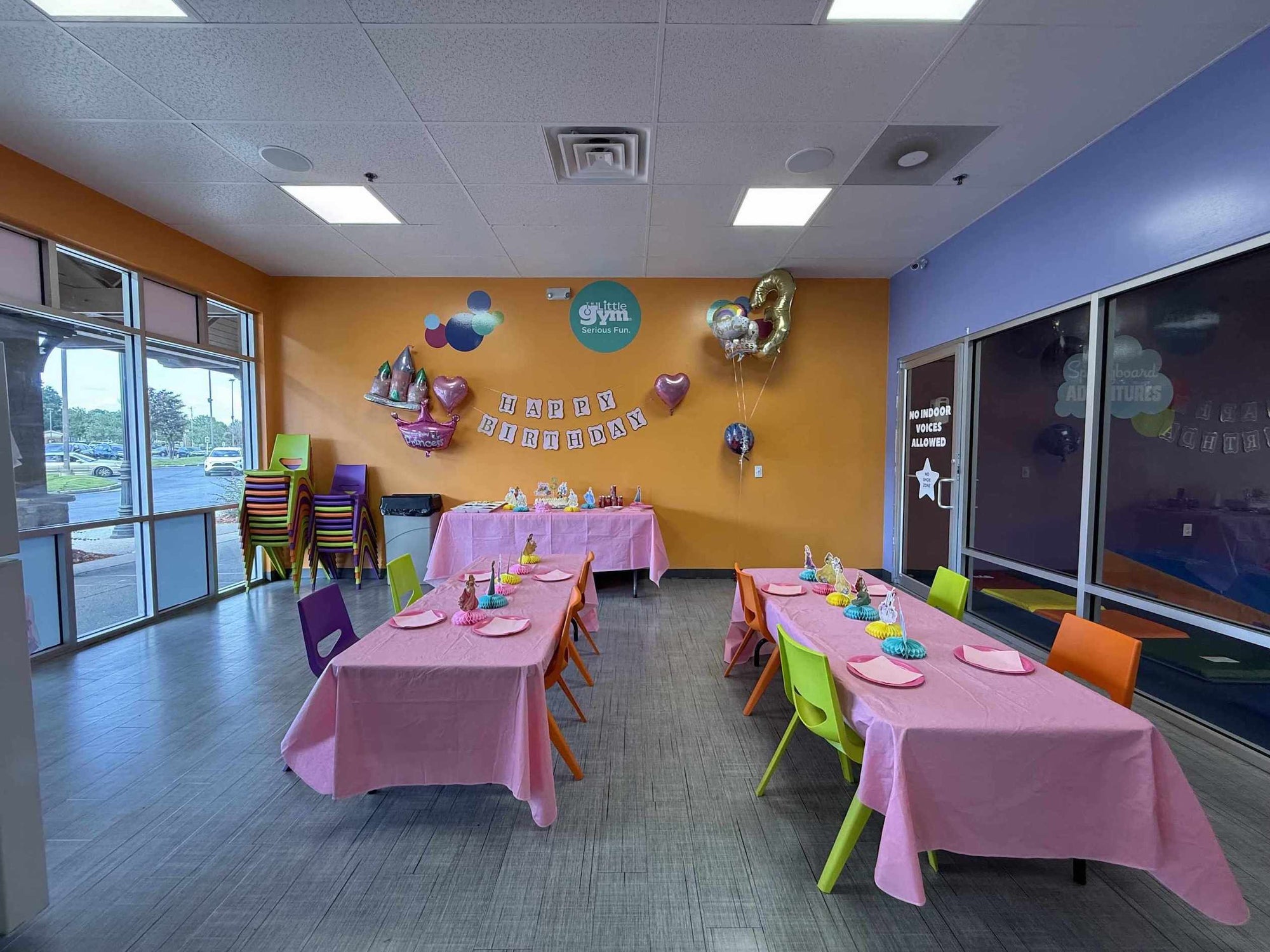 Children's party room with tables set for a birthday celebration, balloons, and decorations at The Little Gym in Johns Creek GA.