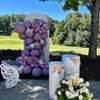 Decorative balloon backdrop with balloons, flowers, and butterflies on a sunny day outdoors.