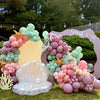 Balloon arch with ocean-themed decorations including a shell and starfish, set outdoors.