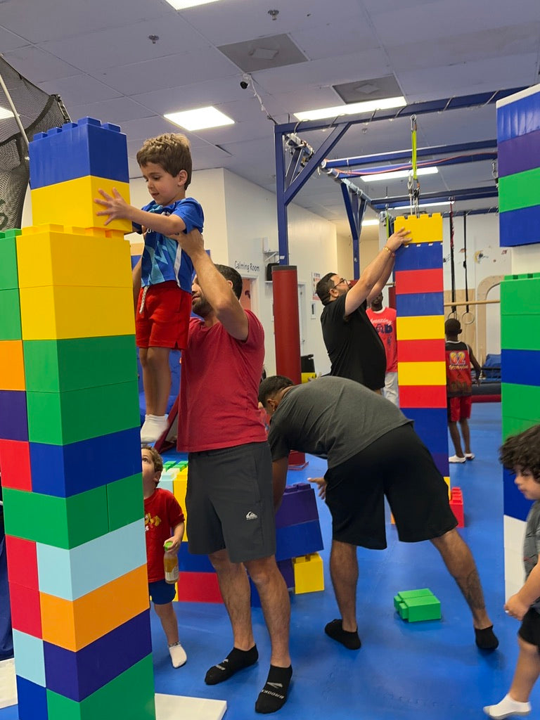Children and adults playing with colorful building blocks in an indoor setting at a birthday party for kids in Atlanta | Confetti Jar