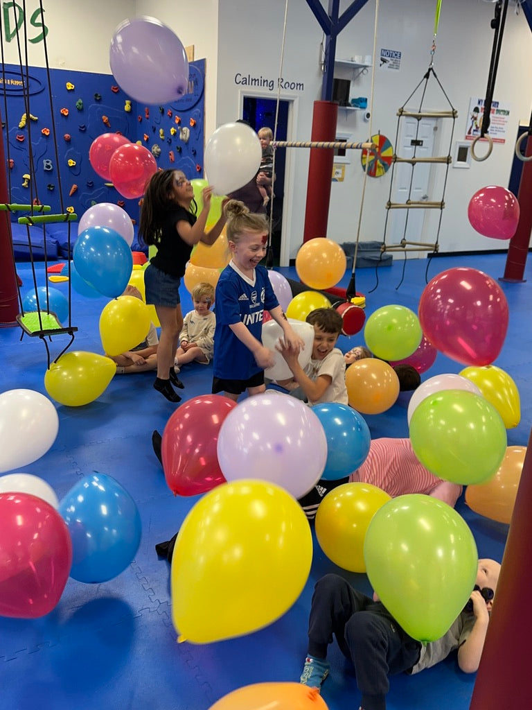 Children playing with colorful balloons in a room with play equipment at a birthday party for kids in Atlanta | Confetti Jar