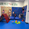 Children playing in a gymnasium with climbing wall and play equipment, featuring 'Jig 2 Fit Kids'at an indoor birthday party for kids in Atlanta | Confetti Jar