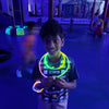 Child wearing a glowing necklace in a dark indoor setting at a birthday party for kids in Atlanta | Confetti Jar